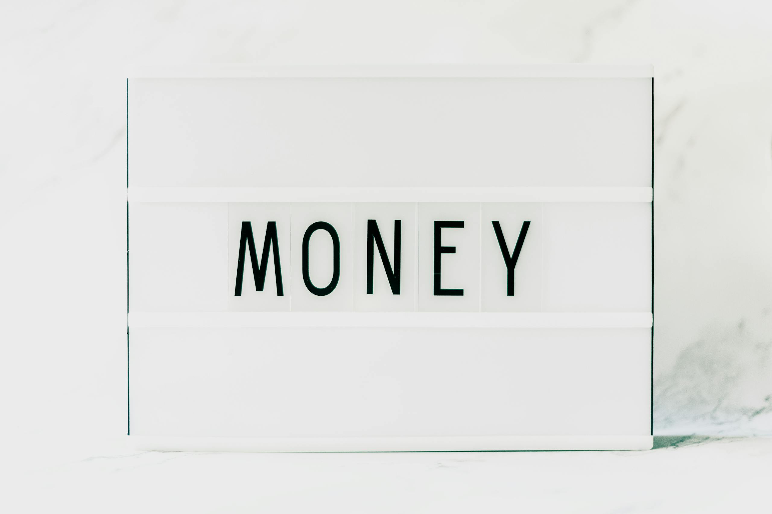 Contemporary minimalist lightbox displaying the word 'Money' on a clean white background.